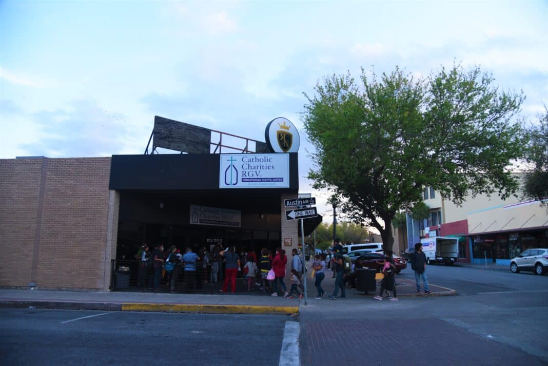 Migrants stand outside the Catholic Charities of the Rio Grande Valley Respite Center in McAllen on March 21, 2021. (The Monitor photo)